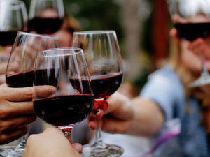 Group of people toasting with glasses of red wine
